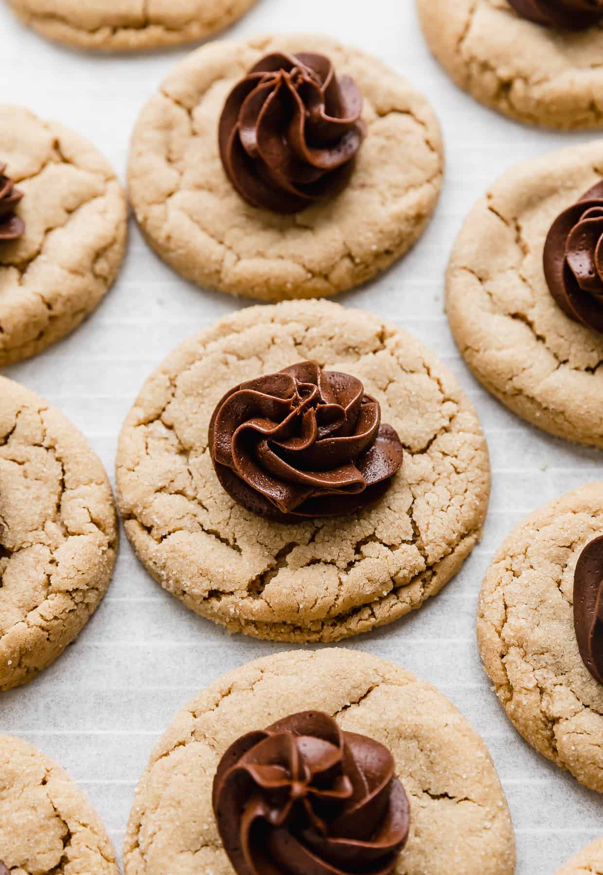 A Crumbl Peanut Butter Blossom Cookie topped with a swirl of fudge frosting.