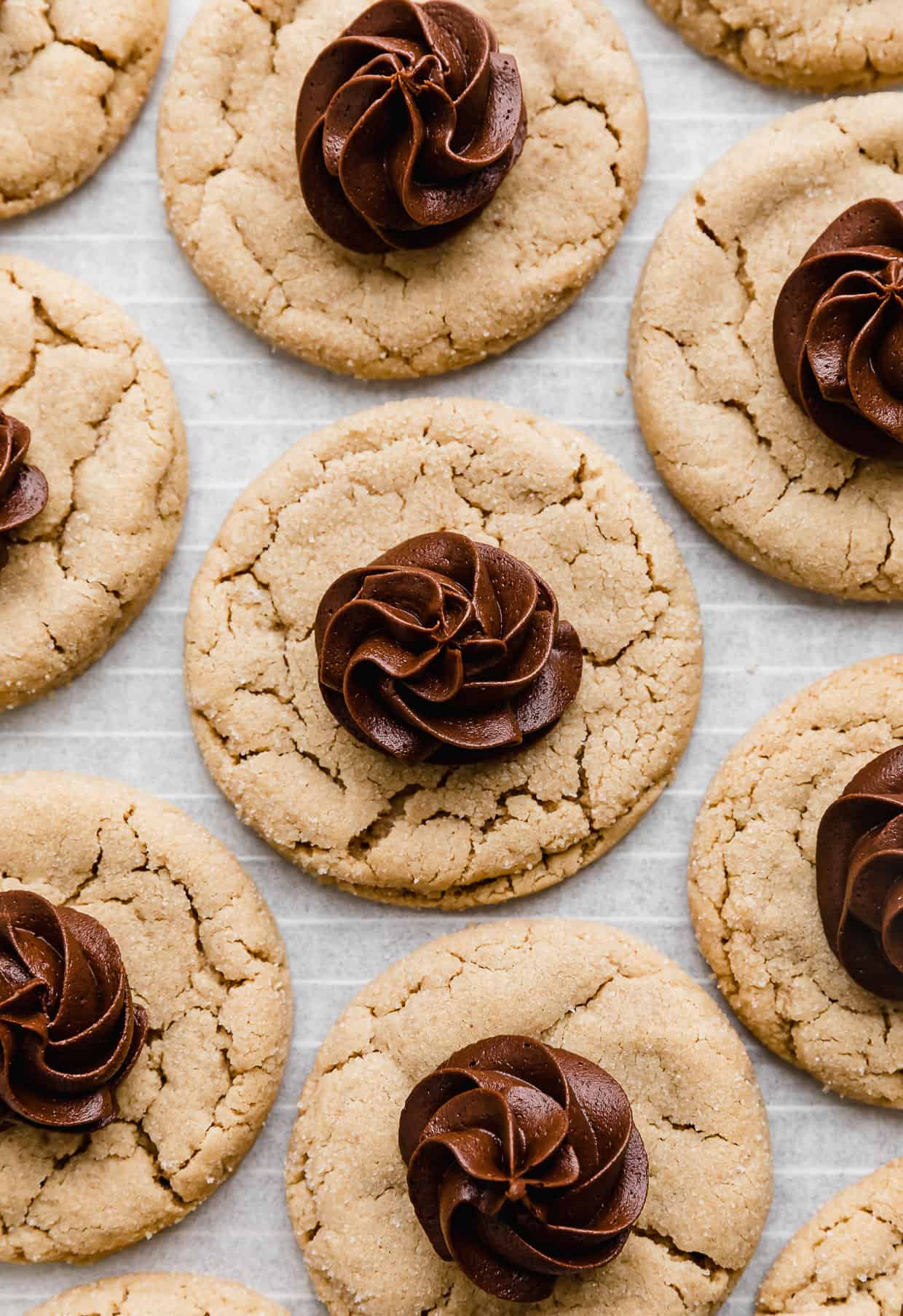Crumbl Peanut Butter Blossom Cookies topped with a swirl of chocolate fudge frosting in the center of each cookie.