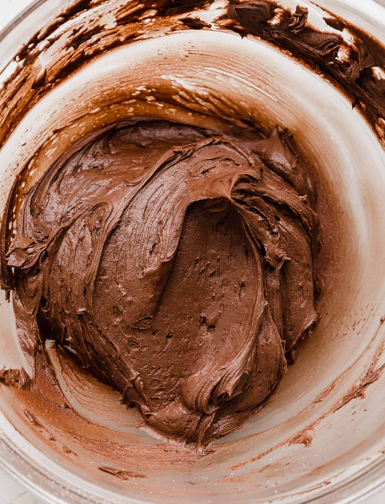 Chocolate frosting in a glass bowl.