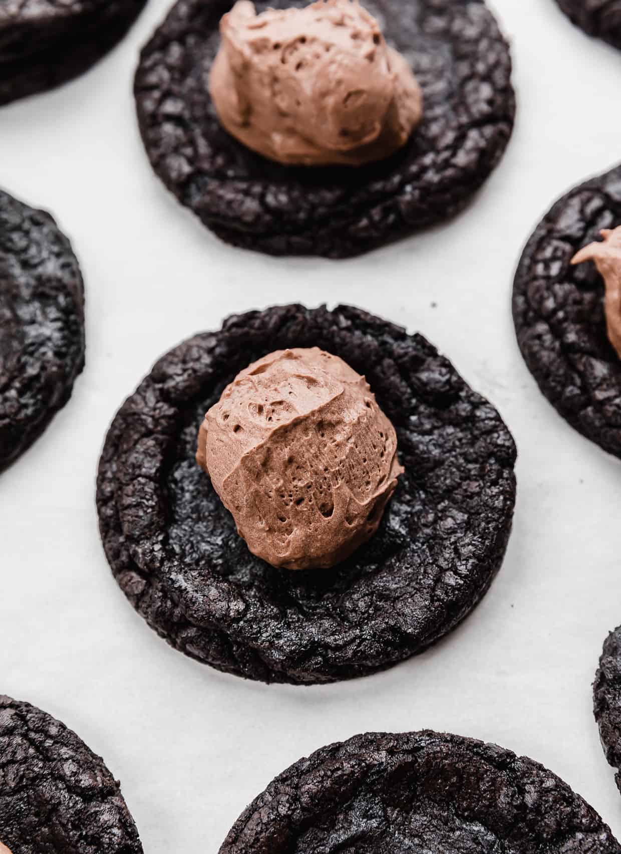 A dollop of chocolate mousse on top of an oreo baked cookie.