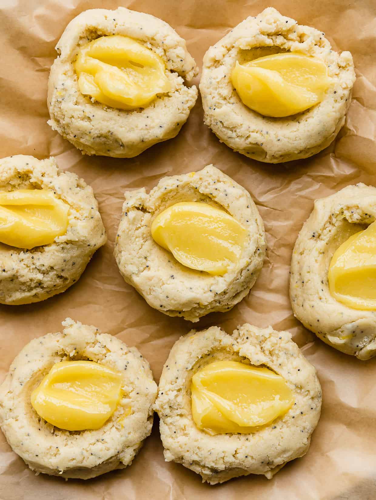 Lemon curd in dollop in the centers of lemon poppy seed cookie dough.