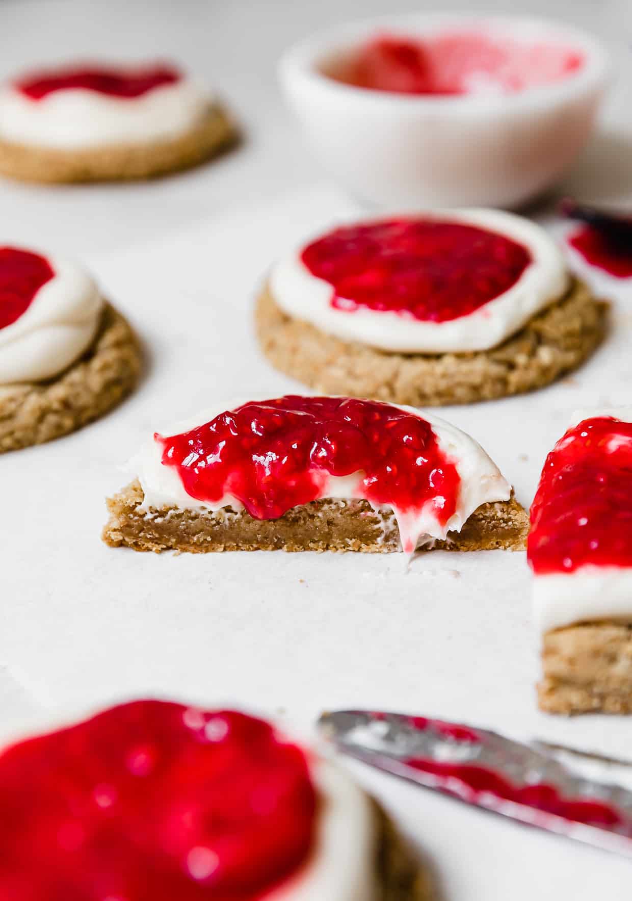 A Raspberry Cheesecake Cookie cut in half on a white table.