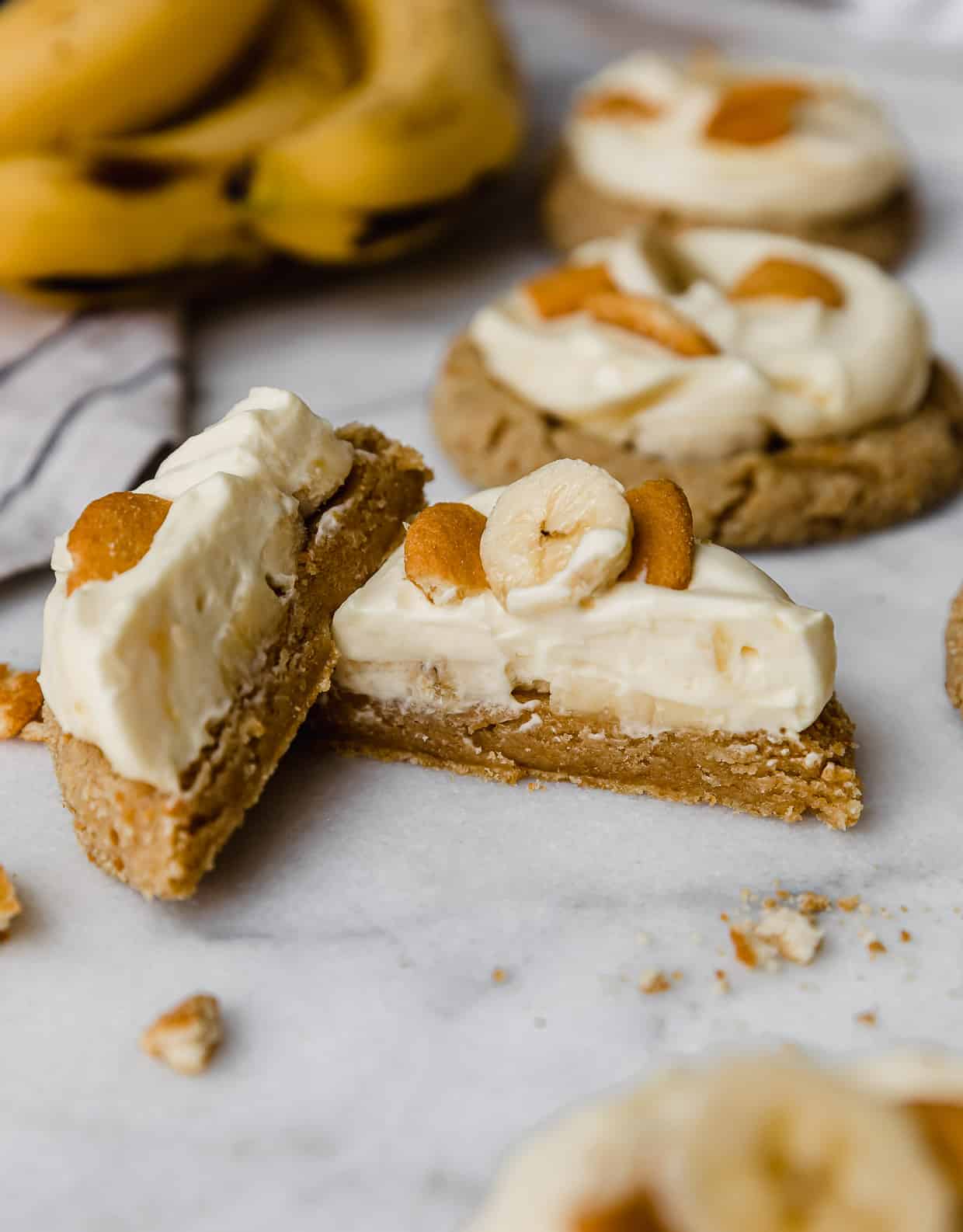 A Banana Cream Pie Cookie cut in half on a marble table.