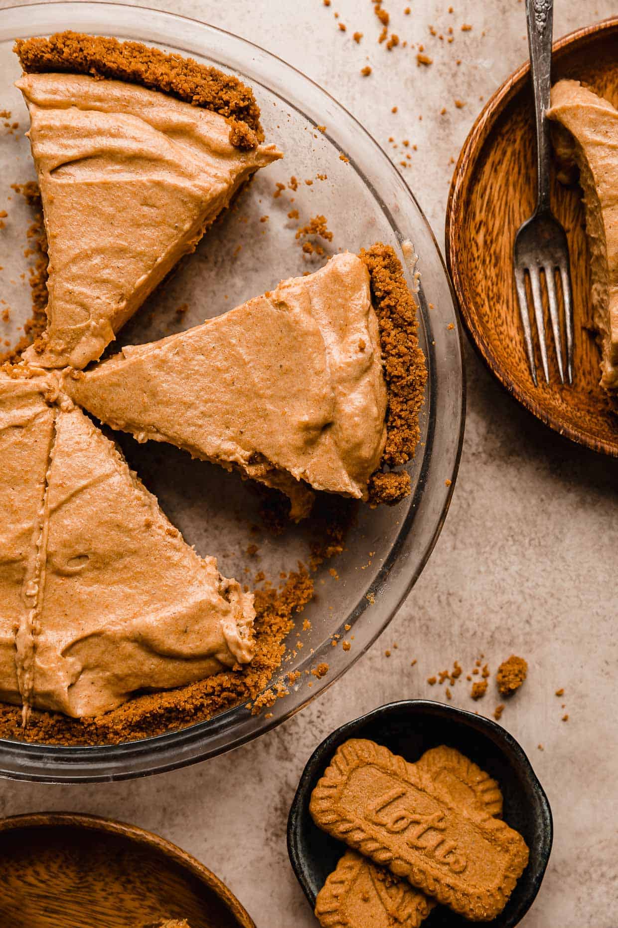 A Biscoff Pumpkin Pie in a pie pan cut into triangles.