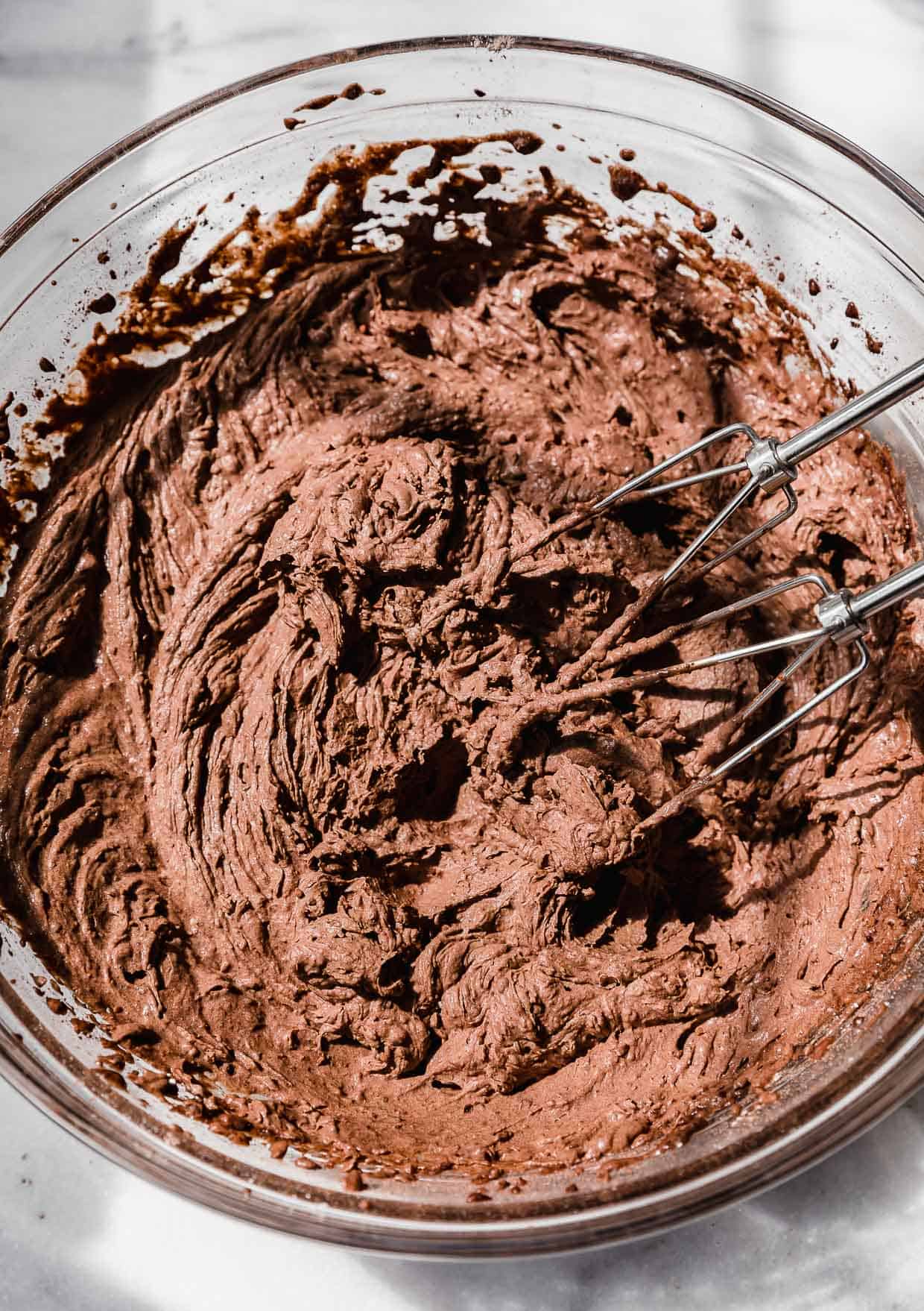 Chocolate pudding frosting in a glass bowl.