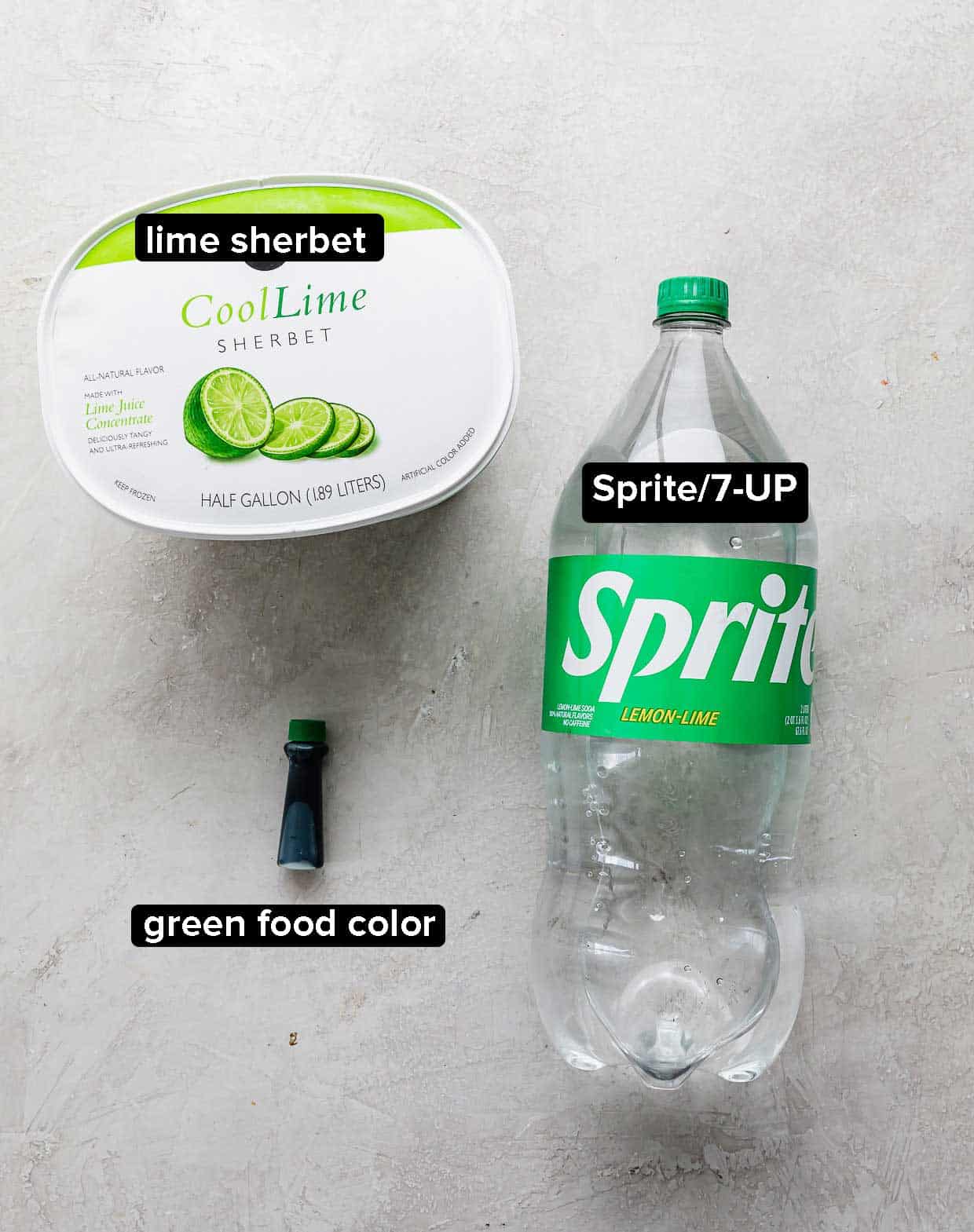 Ingredients used to make Polyjuice Potion on a gray background: lime sherbet, green food color, Sprite.