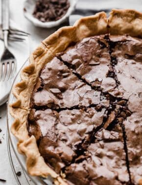 A Brownie Pie in a butter pie crust with several slices in the pie.