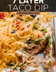 Close up photo of refried bean and guacamole Layered Taco Dip with the words, "7 Layer taco dip" written in white text over the photo.
