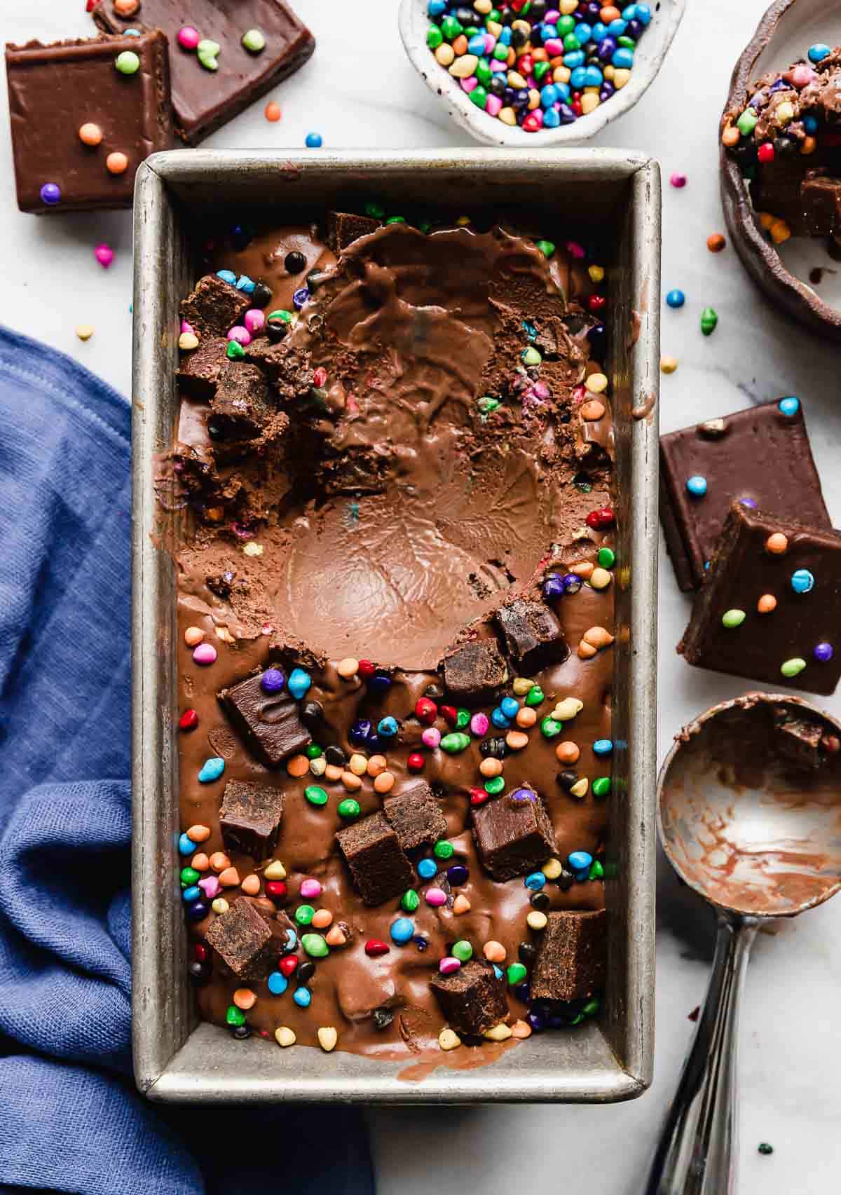 Cosmic Brownie Ice Cream in a silver bread pan with a scoop of ice cream missing from the pan.