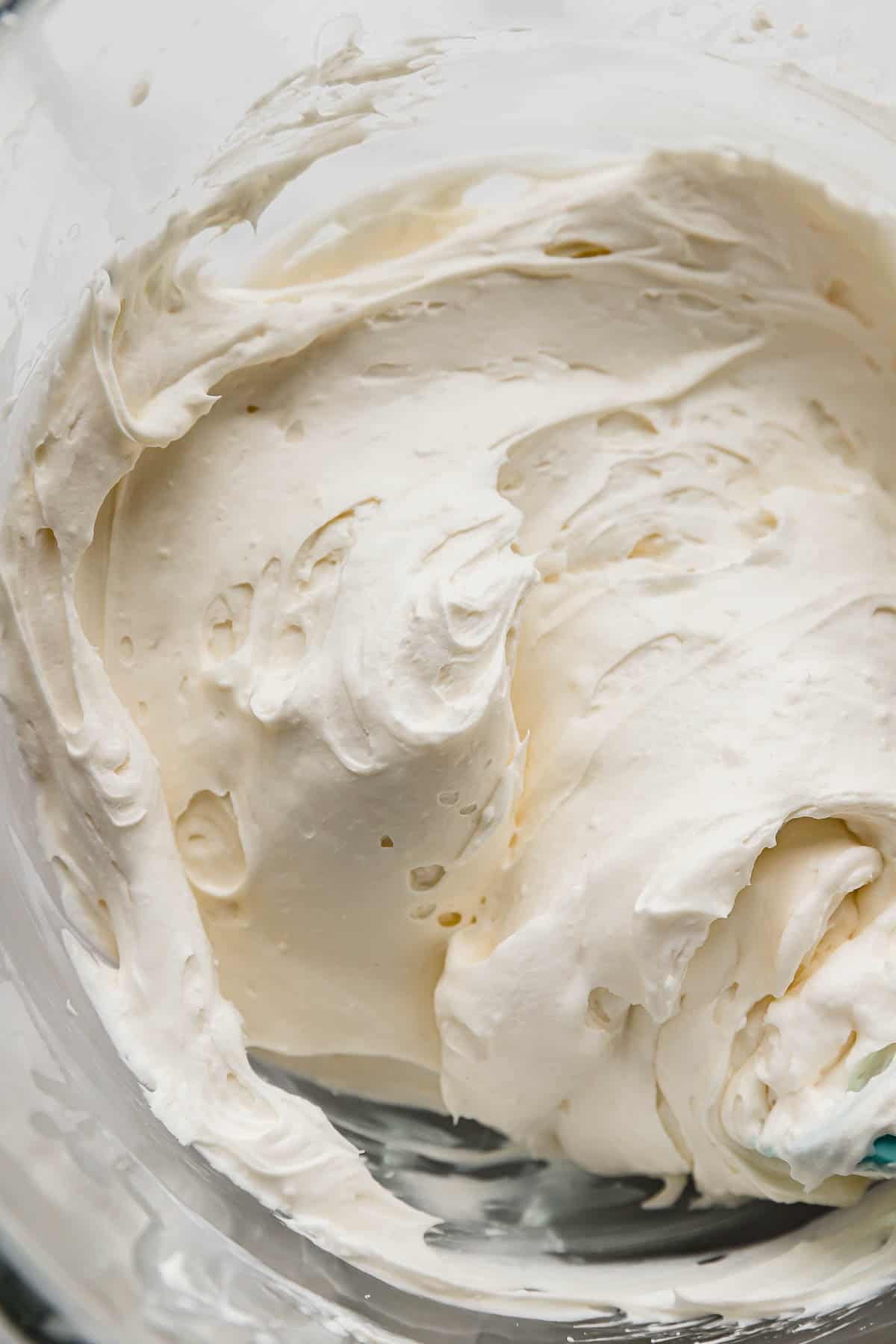 A close up of Cream Cheese Whipped Cream Frosting in a glass bowl.