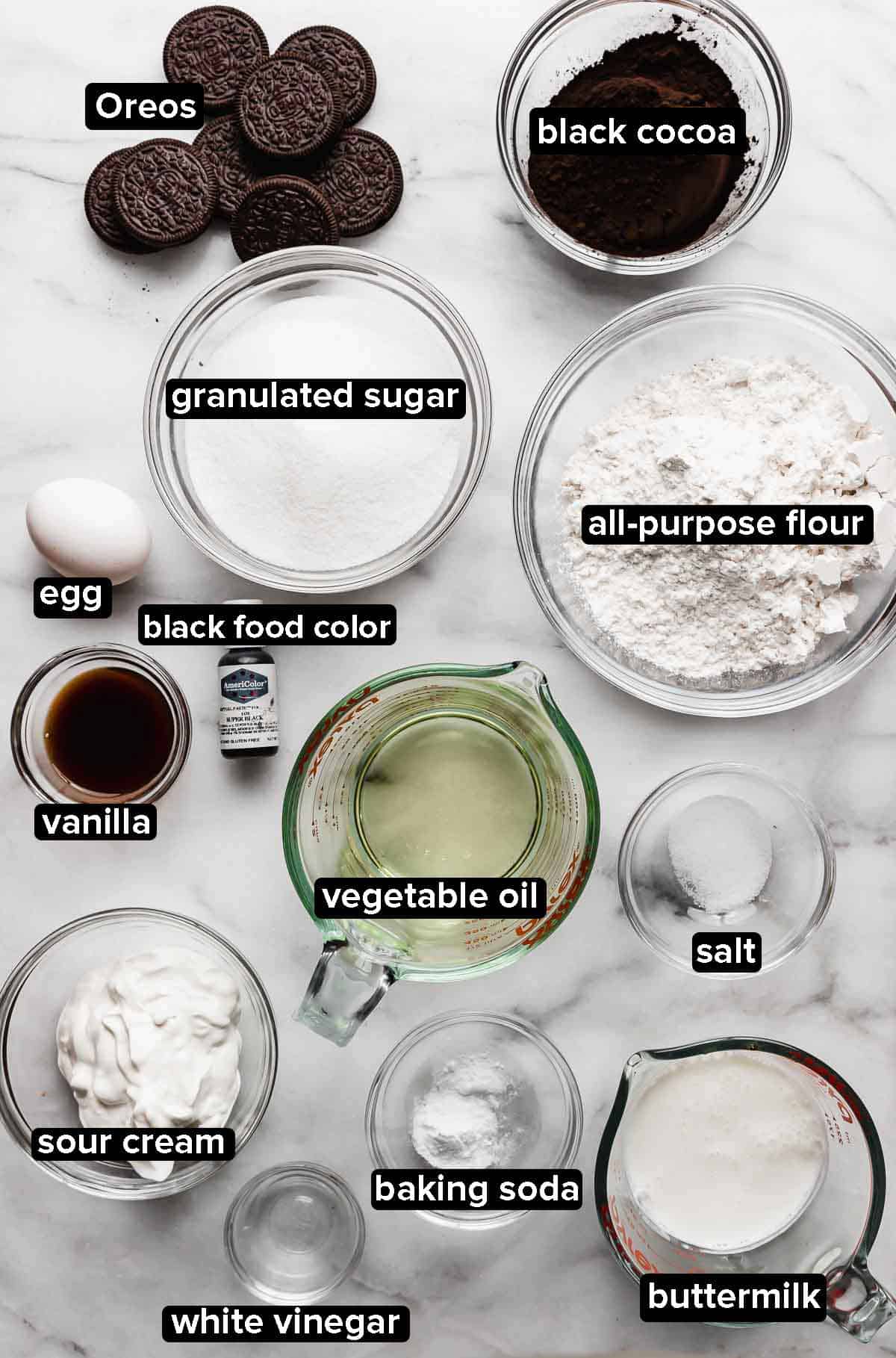 Oreo Cupcake ingredients portioned into glass bowls on a white background.