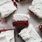 A Red Velvet Brownie square topped with a whipped cream frosting, laying on its side.