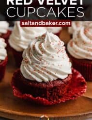 A red velvet cupcake topped with cream cheese frosting with the words, "Red Velvet Cupcakes" written in white text over the photo.