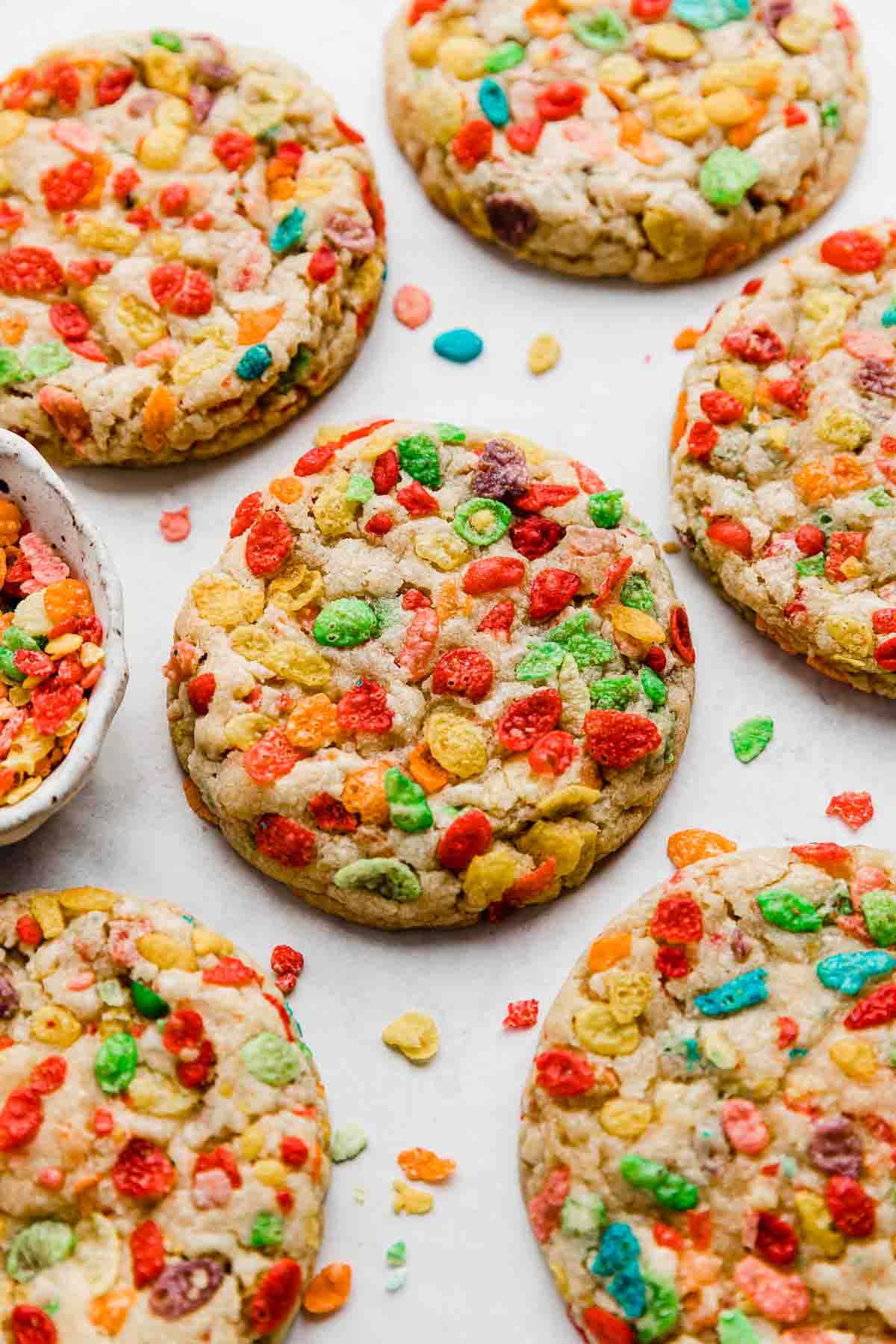 Fruity Pebbles Cookies studded with fruity pebbles cereal, on a white background.