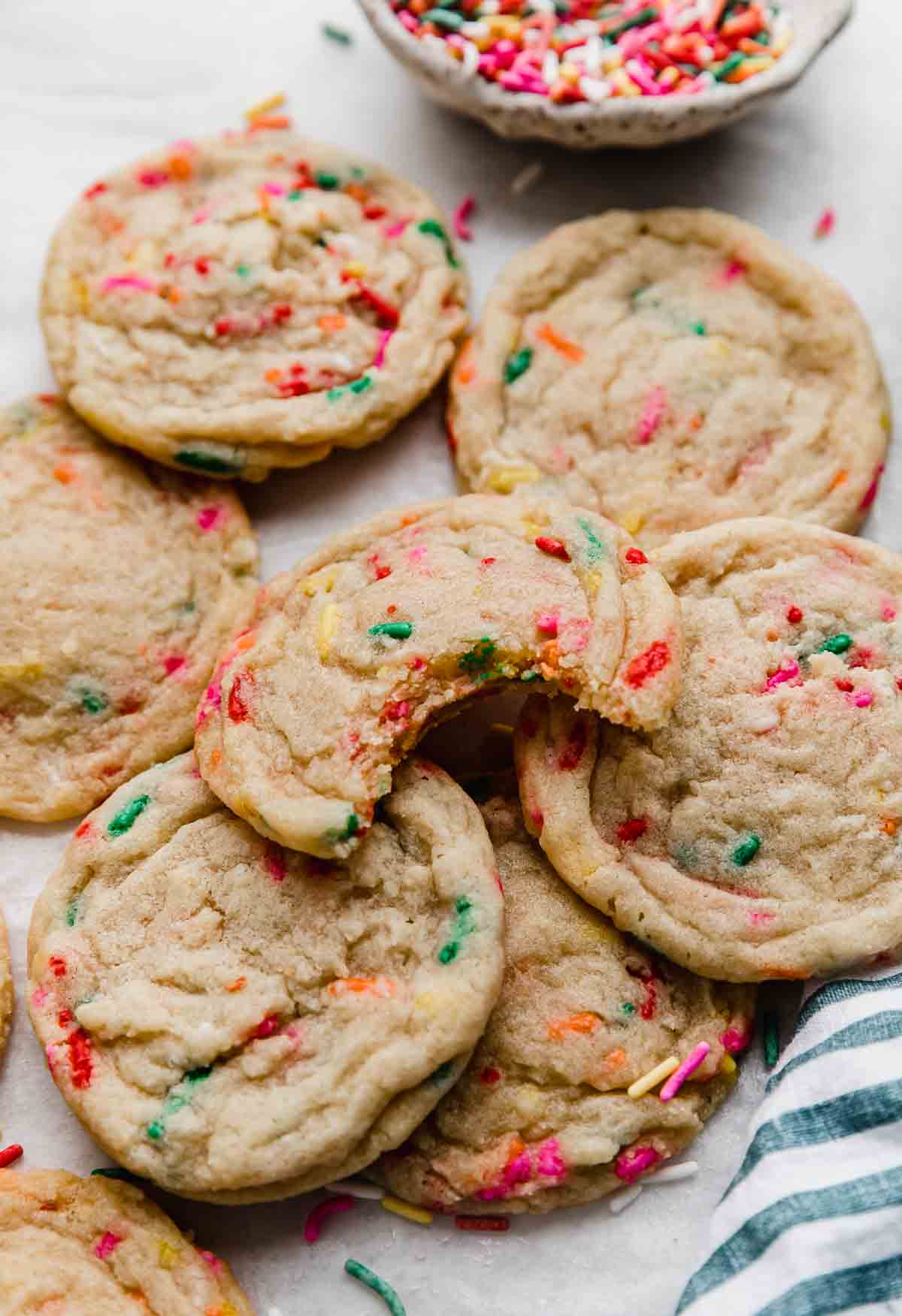 A stack of Funfetti Cookies with a single cookie having a bite taken out of it.
