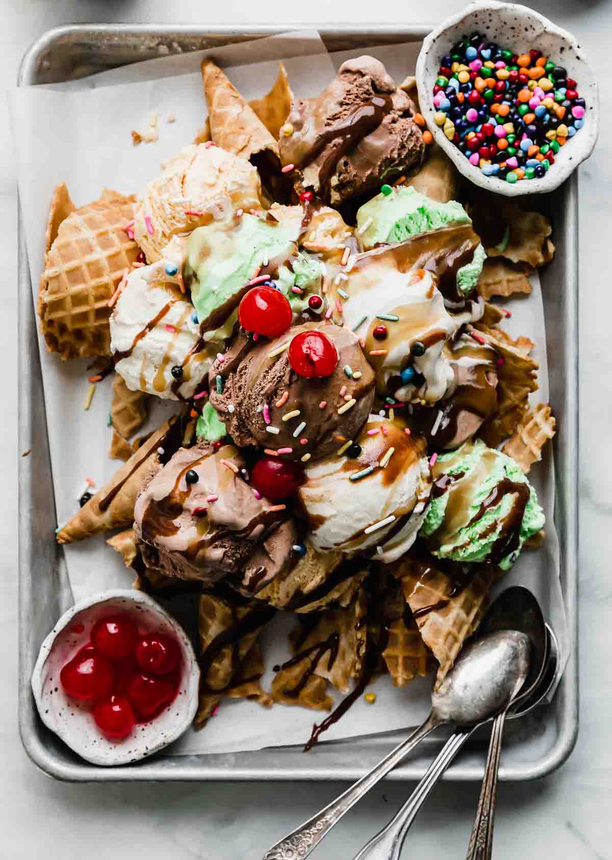 Waffles cones crushed underneath scoops of vanilla, chocolate, and mint ice cream with hot fudge, butterscotch sauce, and sprinkles over the Ice Cream Nachos.