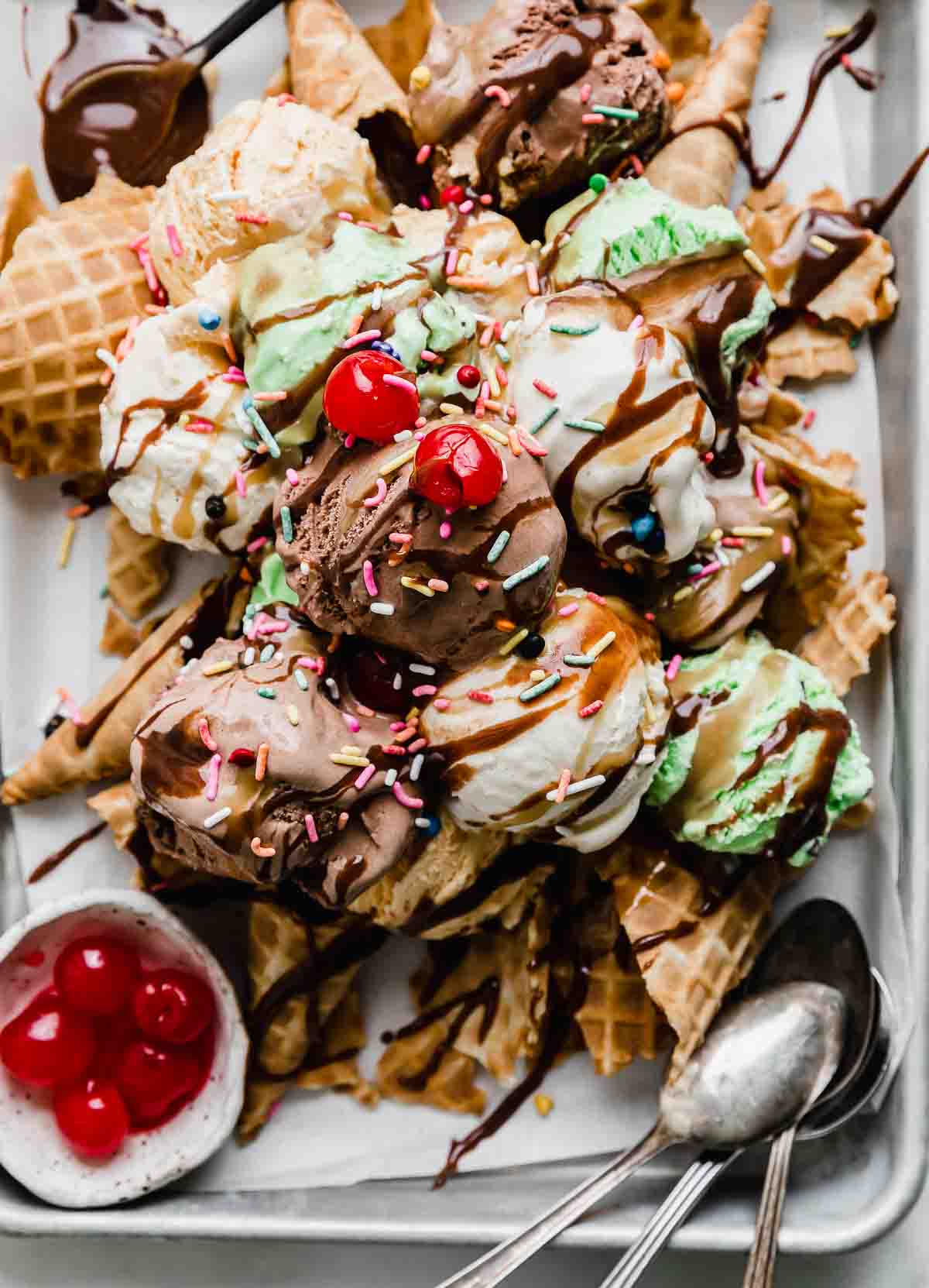 Close up of Ice Cream Nachos topped with hot fudge, butterscotch sauce, sprinkles, and maraschino cherries.