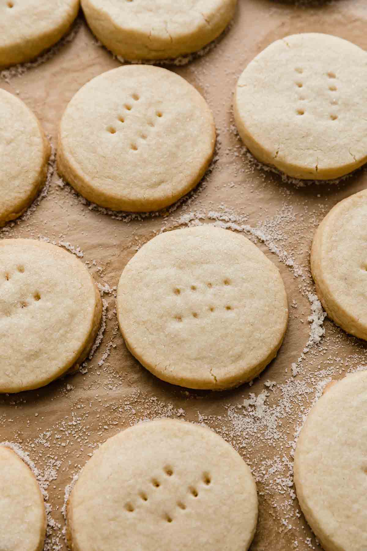 Round shortbread cookies on a tan colored parchment paper. 