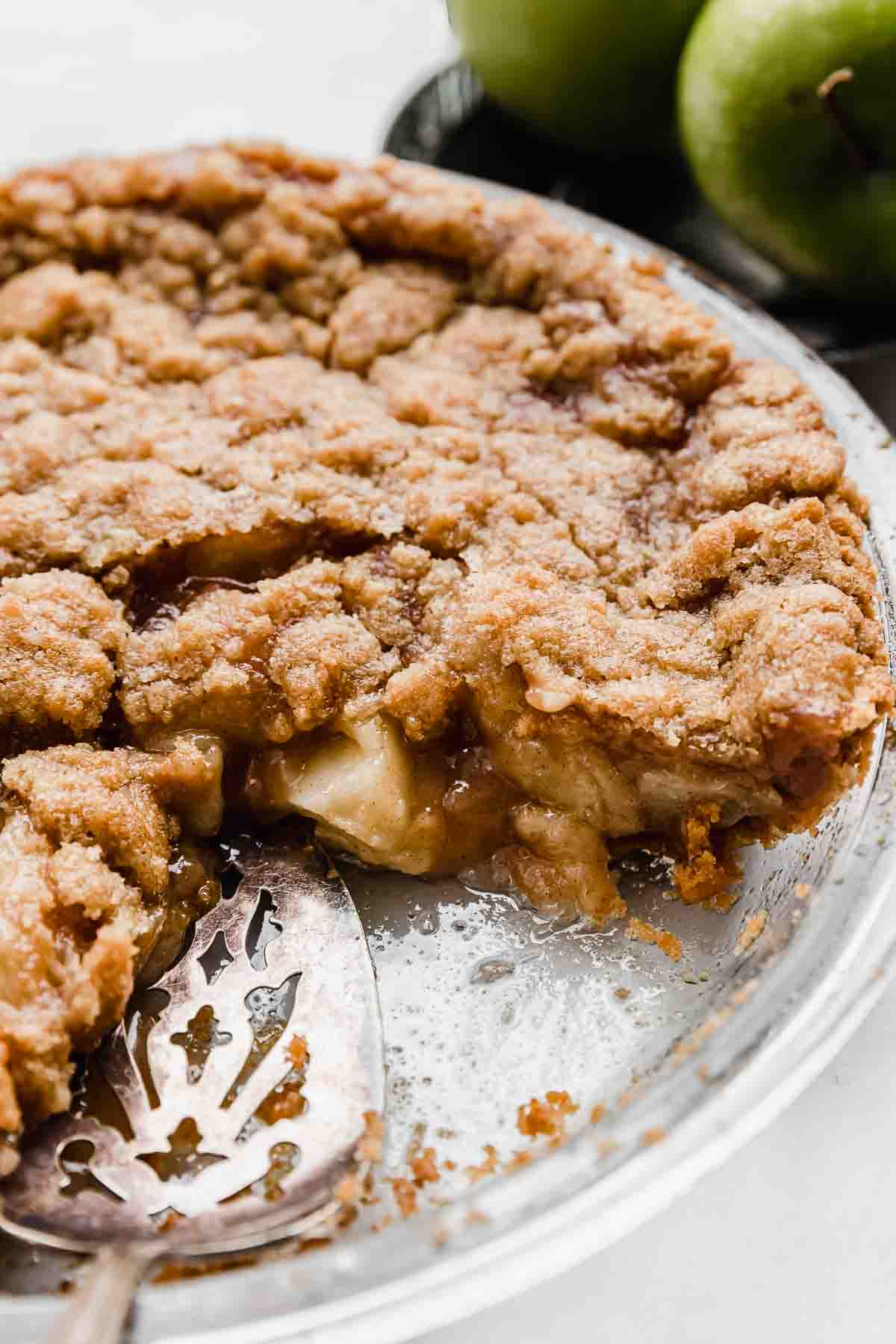 An Apple Pie with Graham Cracker Crust sliced, on a white background.