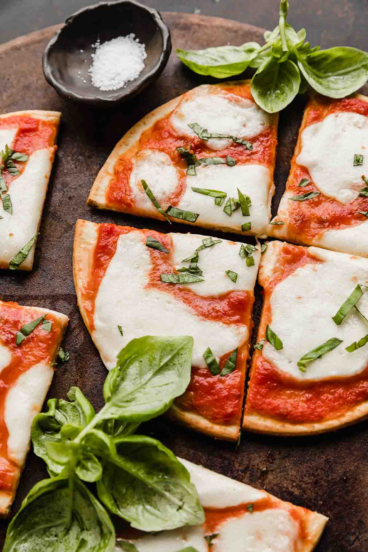 Margherita Flatbread pizza on a brown pizza stone.