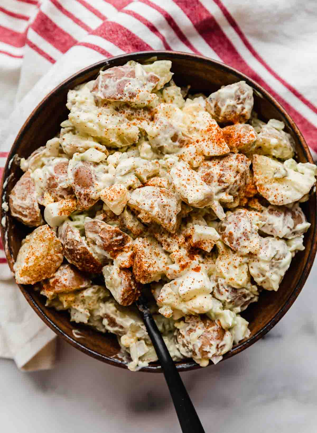 Potato Salad with sweet relish in a brown bowl on a marble background.