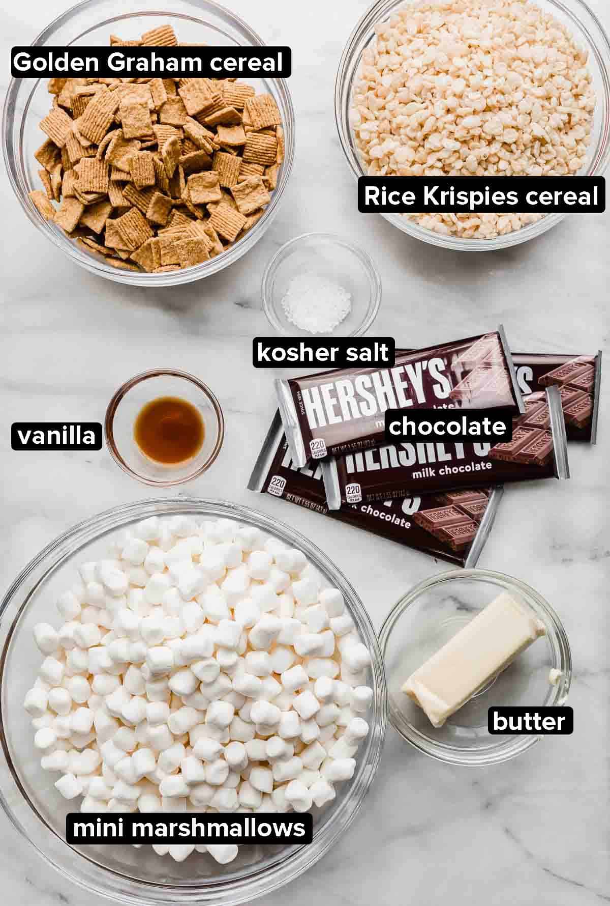 S'more Rice Krispie Treats ingredients on a gray and white marble background. 