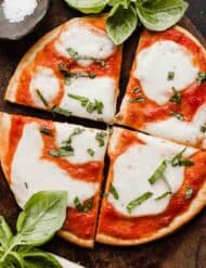 Close up image of Margherita Flatbread pizza topped with crushed tomatoes, fresh mozzarella, and fresh basil.