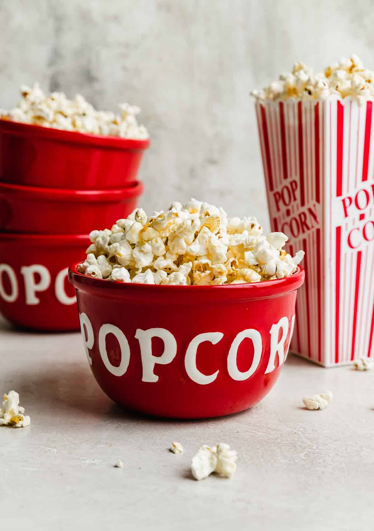 Kettle corn in a red bowl with the words, "popcorn" written in white on the bowl.