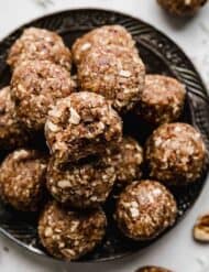 German Chocolate Cake Protein Balls on a black plate.