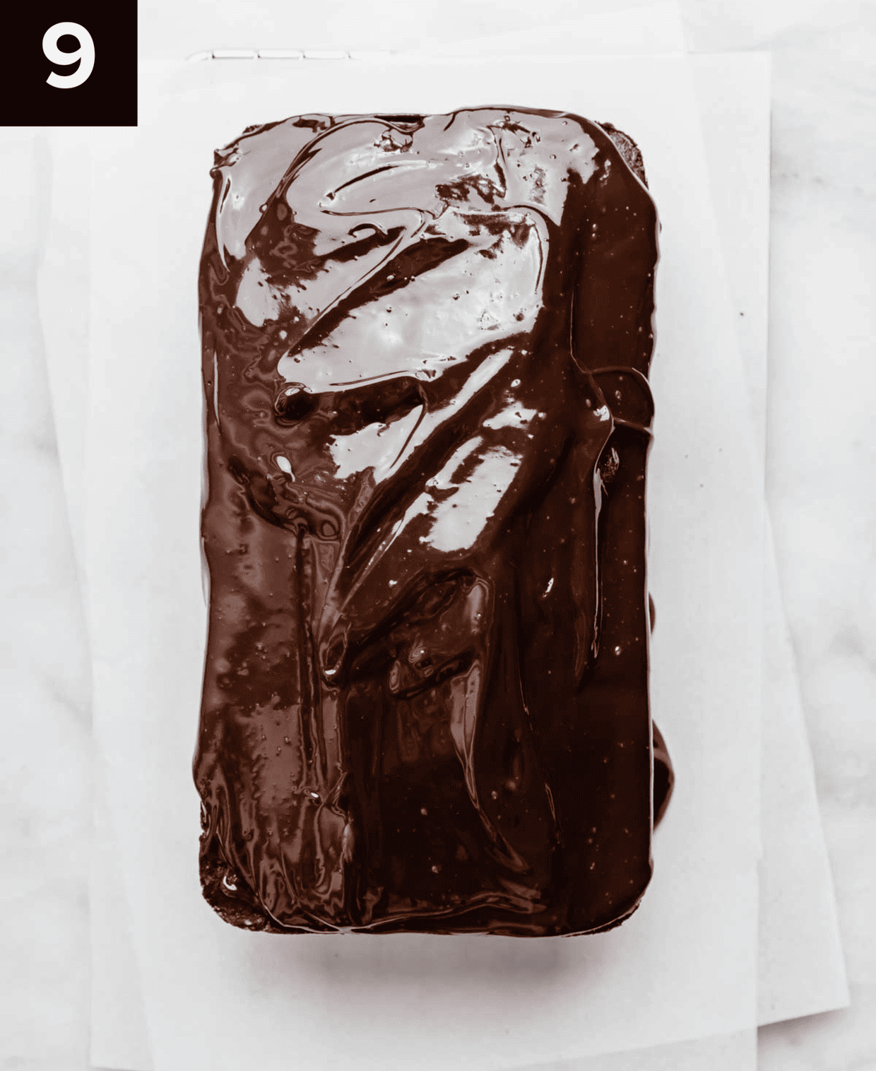 Overhead photo of a chocolate glazed Chocolate Pound Cake on a white background.