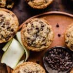 Mini chocolate chip topped Zucchini Chocolate Chip Muffins on a brown plate.
