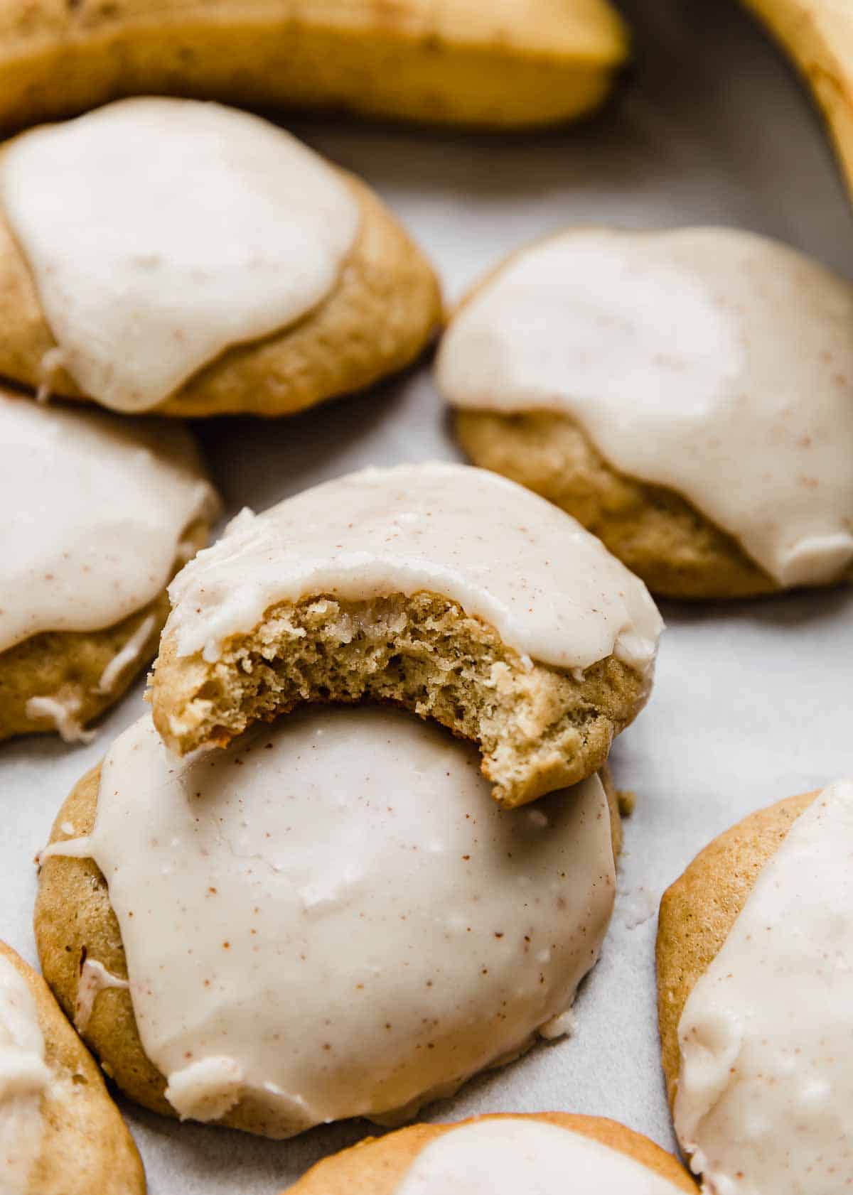 Frosted Banana Cookies with one cookie having a bite taken out of it.