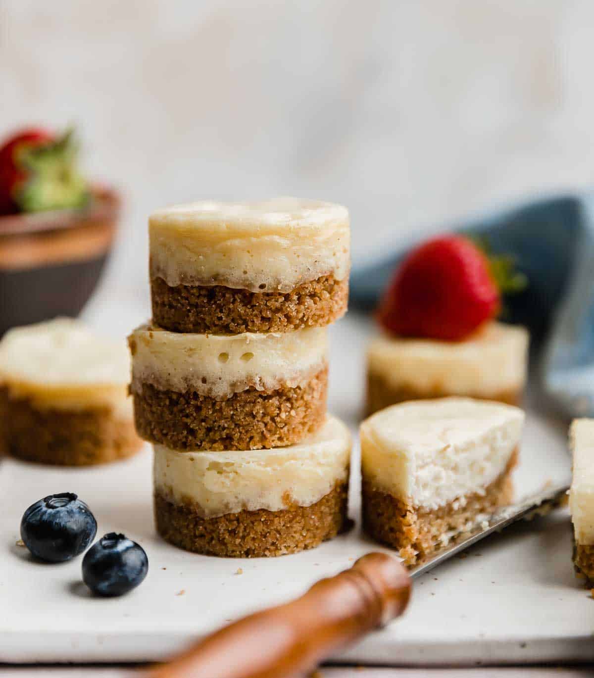 A stack of three baked mini cheesecakes against a white background.