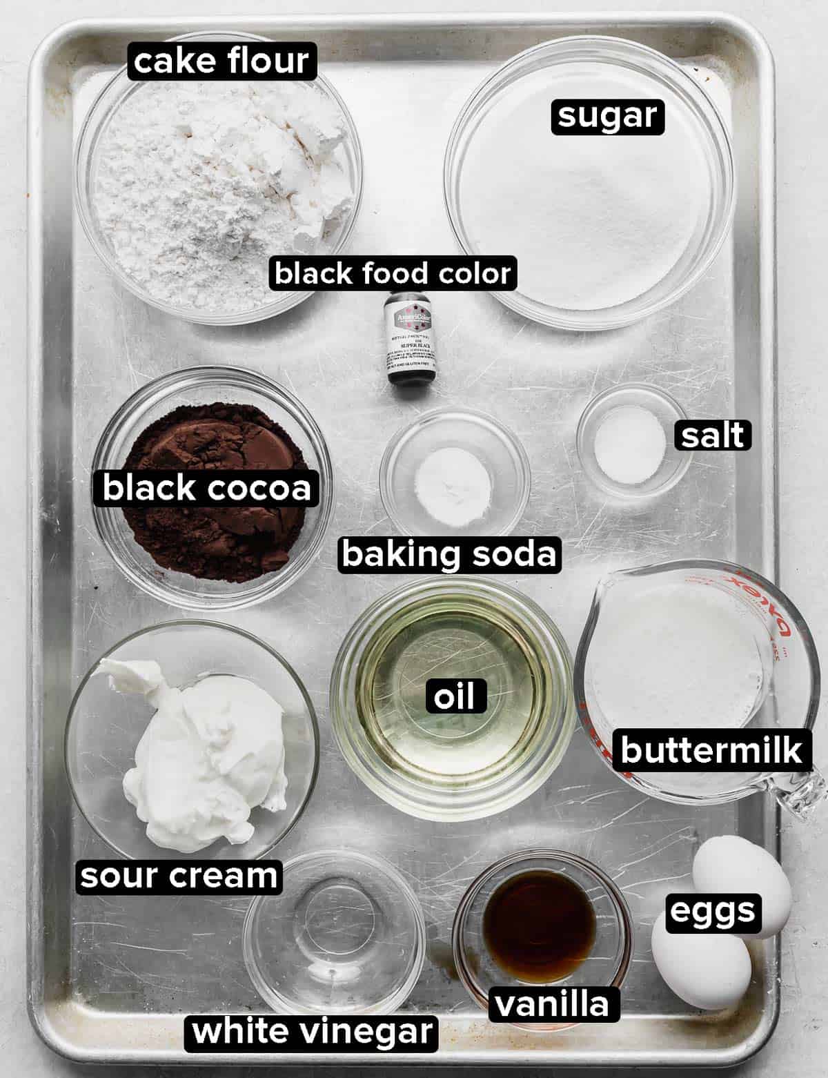 Black Velvet Cake ingredients portions into glass bowls on a silver baking sheet.