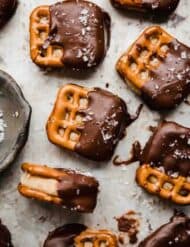 Square pretzels with a peanut butter filling sandwiched between two pretzels and then dipped halfway in chocolate.