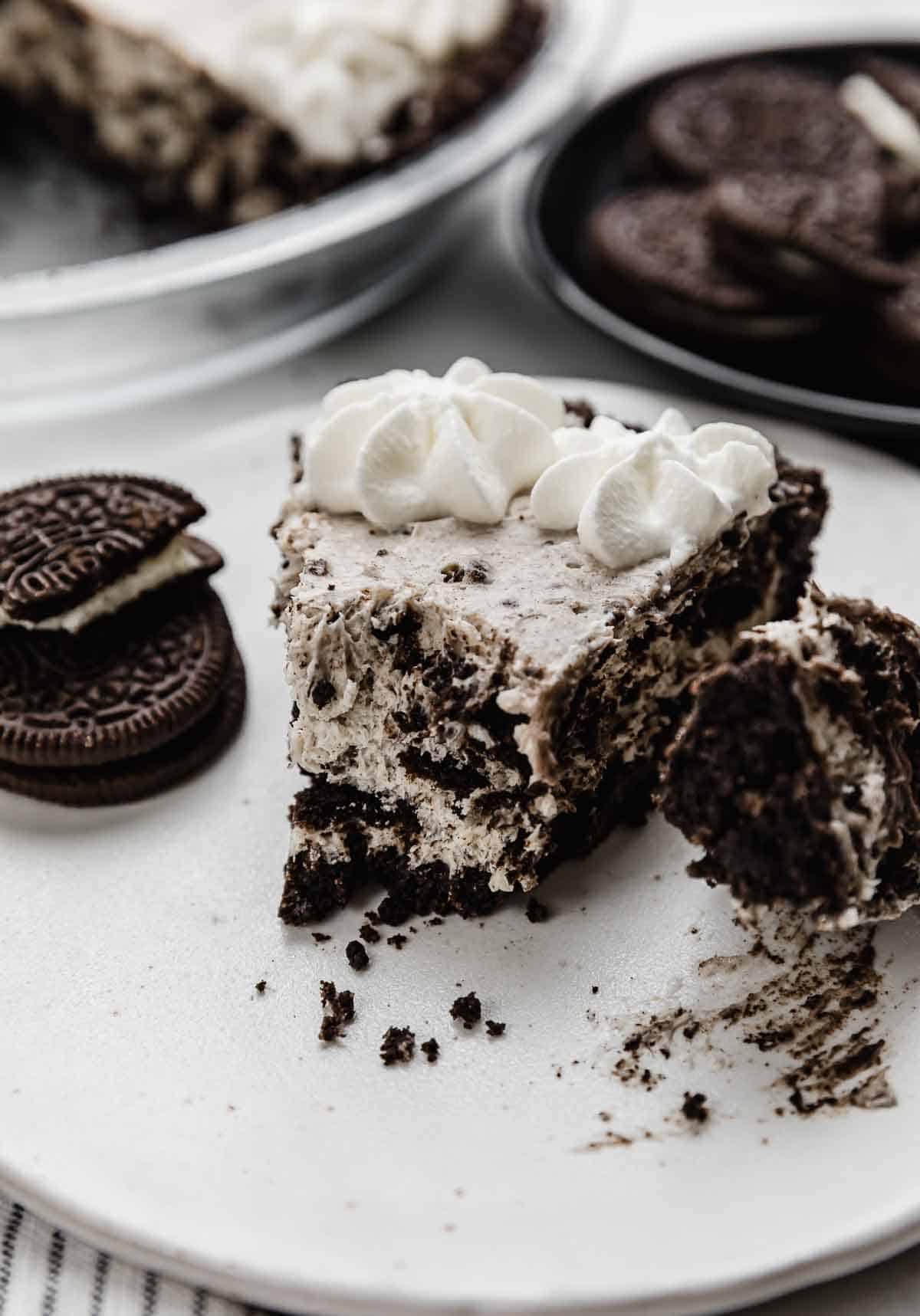 A slice of Cookies and Cream Pie on a white plate.