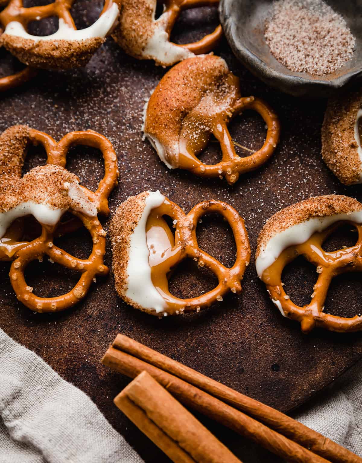 Caramel White Chocolate Cinnamon Dipped Pretzels on a brown background.