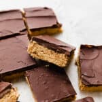 No Bake Chocolate Peanut Butter Bars cut into squares on a white background.
