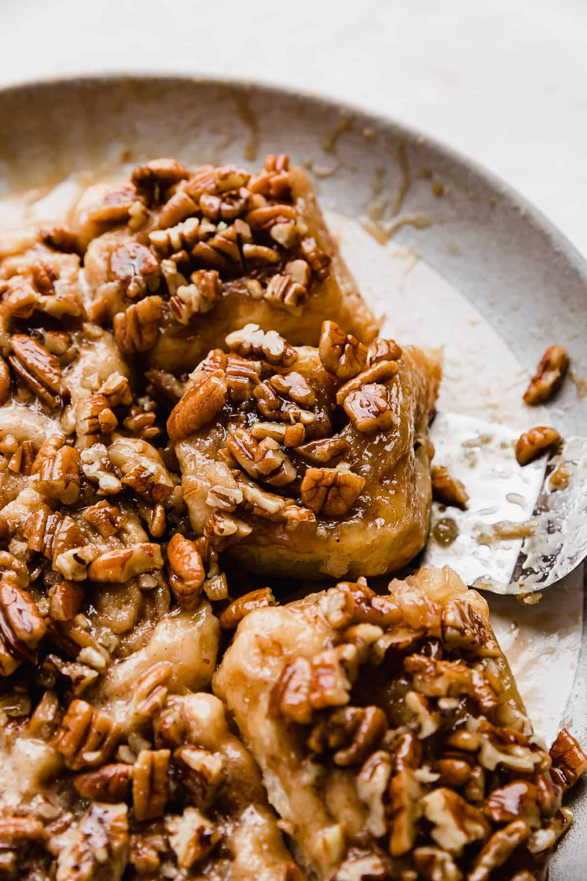 Pecan Sticky Buns on a white and grey plate.