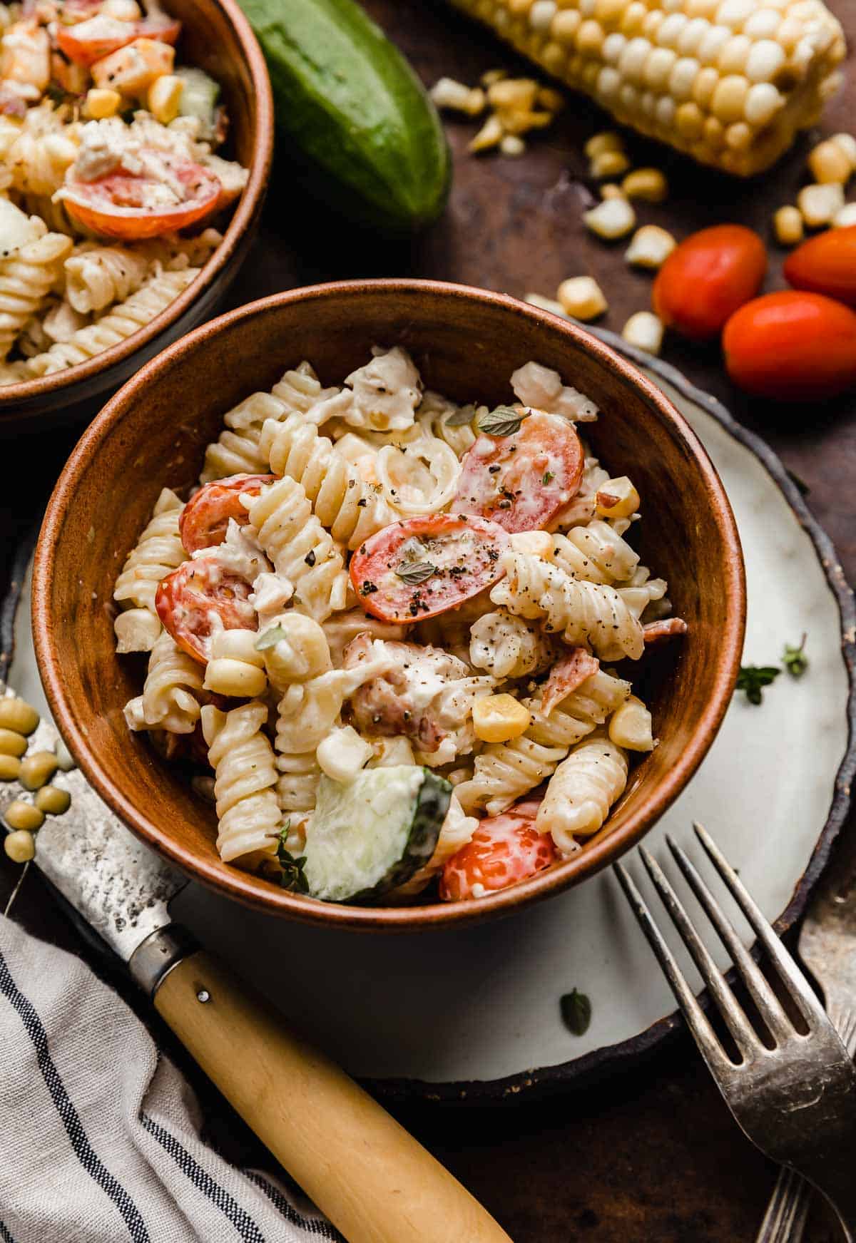 A brown bowl filled with Chicken Bacon Ranch Pasta Salad.