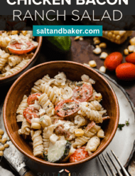 Rotini pasta mixed with tomatoes, chicken, cucumbers, corn, and ranch dressing in a brown bowl.