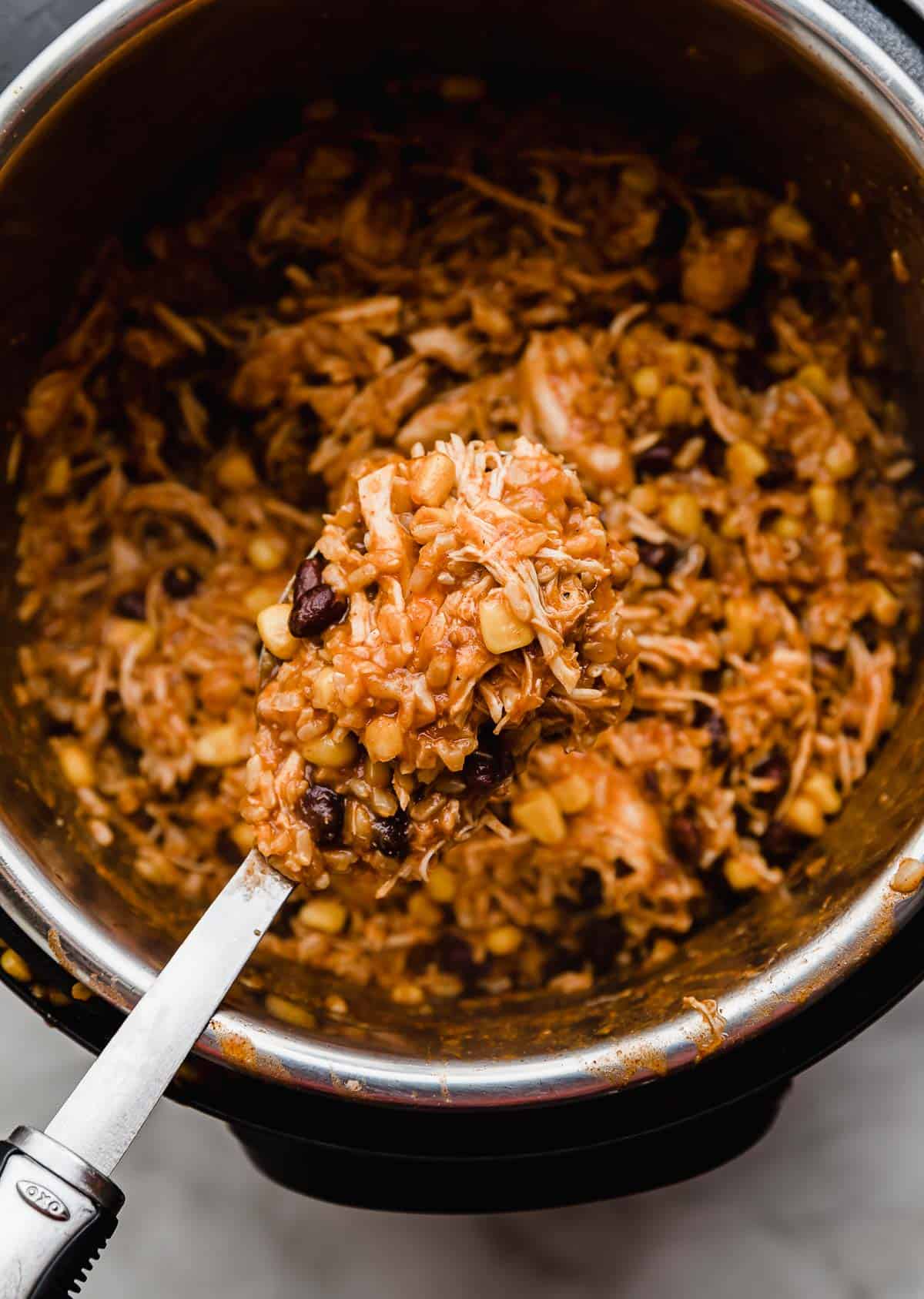 A large spoon holding Instant Pot Chicken Taco  mixture on it.