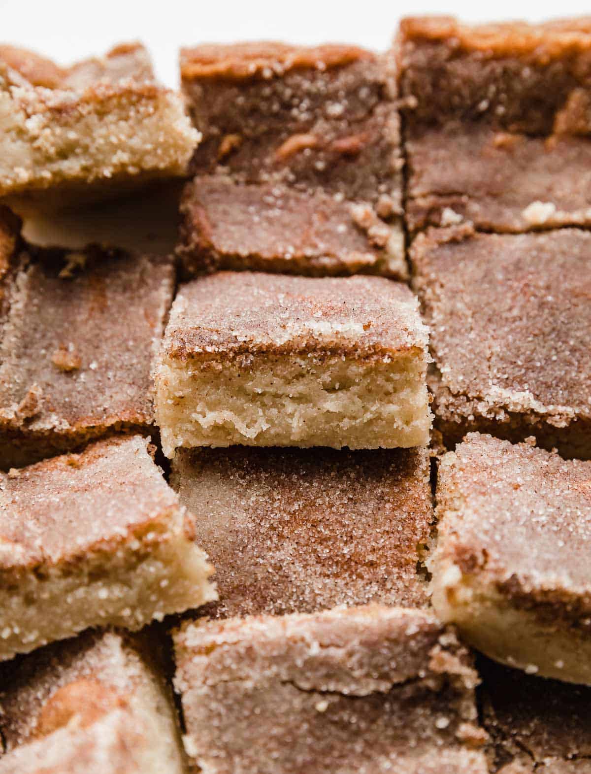 Cinnamon sugar coated Snickerdoodle Bars cut into squares.