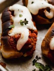 The best Italian Meatball Subs topped with melted cheese, on a baking sheet.