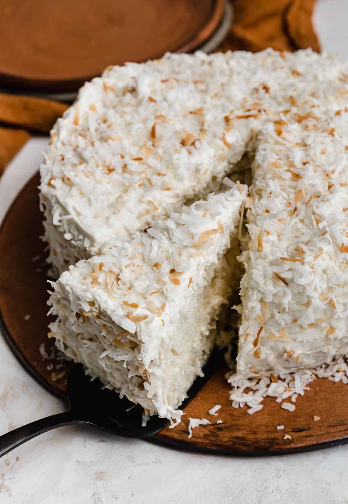 A double layer Coconut Cake Recipe made from a cake box mix with toasted and sweetened shredded coconut sprinkled over the full cake.