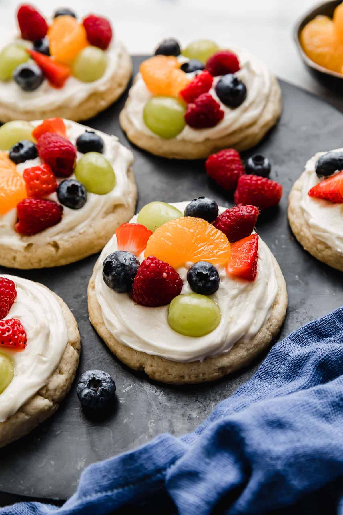 Crumbl Fruit Pizza Cookies on a black plate.