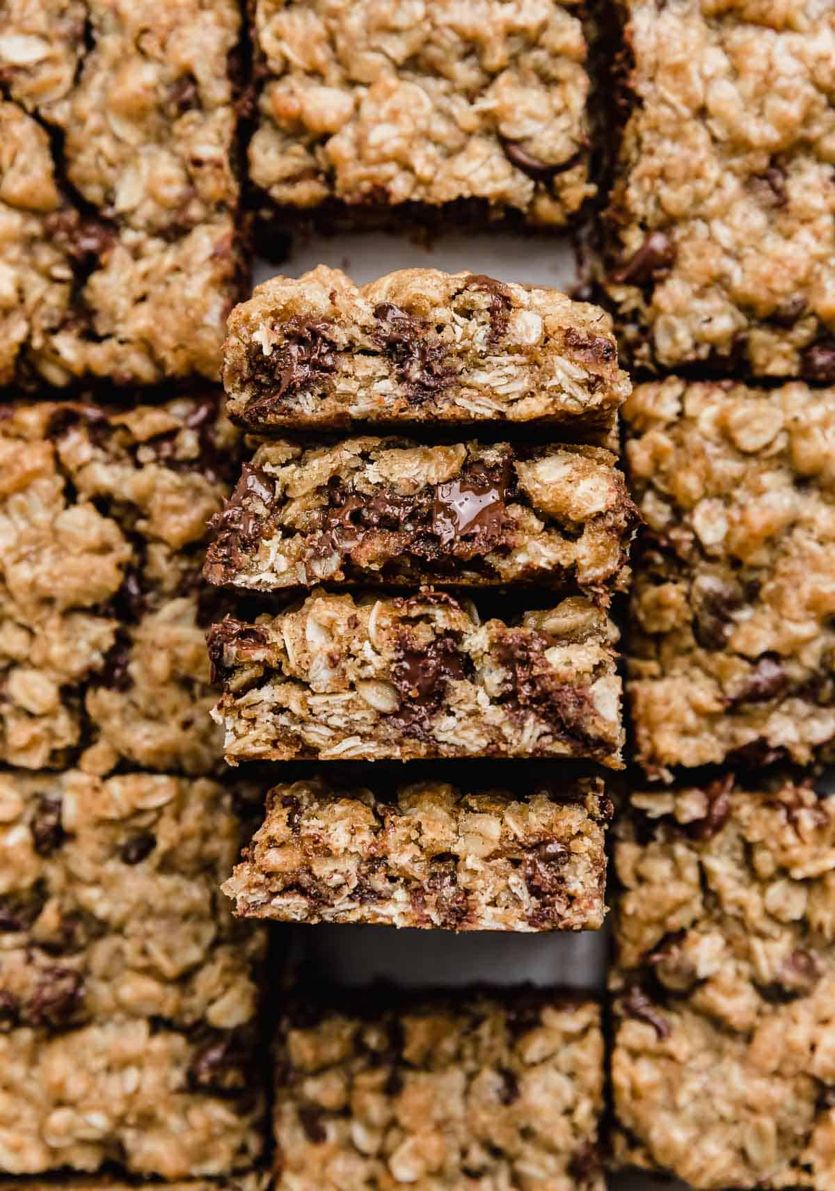 Four Brown Butter Chocolate Chip Oatmeal Cookie Bars balancing on their edges to showcase the interior chewy oatmeal cookie bars. 