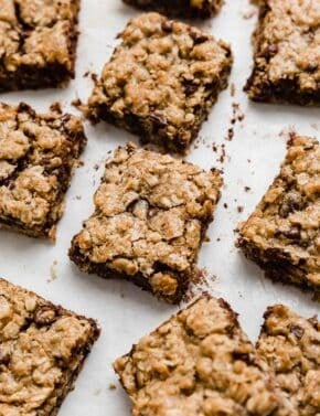 Chocolate chip oatmeal cookie bars cut into squares on a white background.