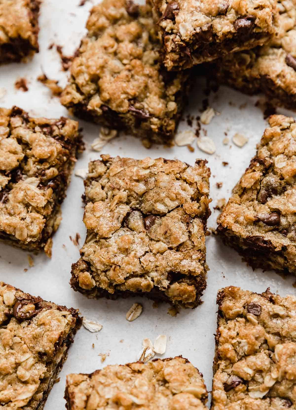 Brown butter oatmeal cookie bars with chocolate chips, cut into squares on a white background.