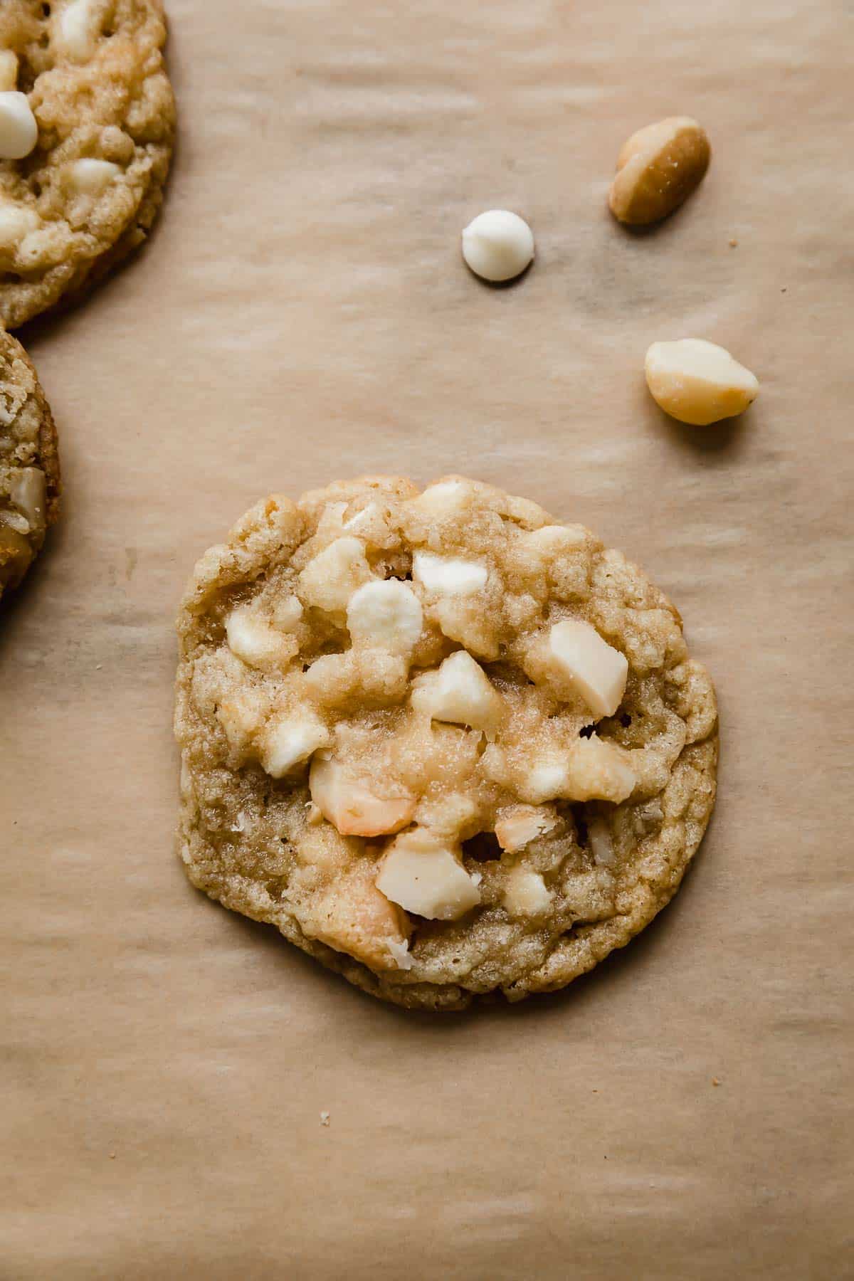 One White Chocolate Macadamia Nut Cookie on a Kraft colored parchment paper.